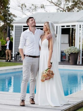 Bride and Groom laughing and smiling with a blue pool in the background 