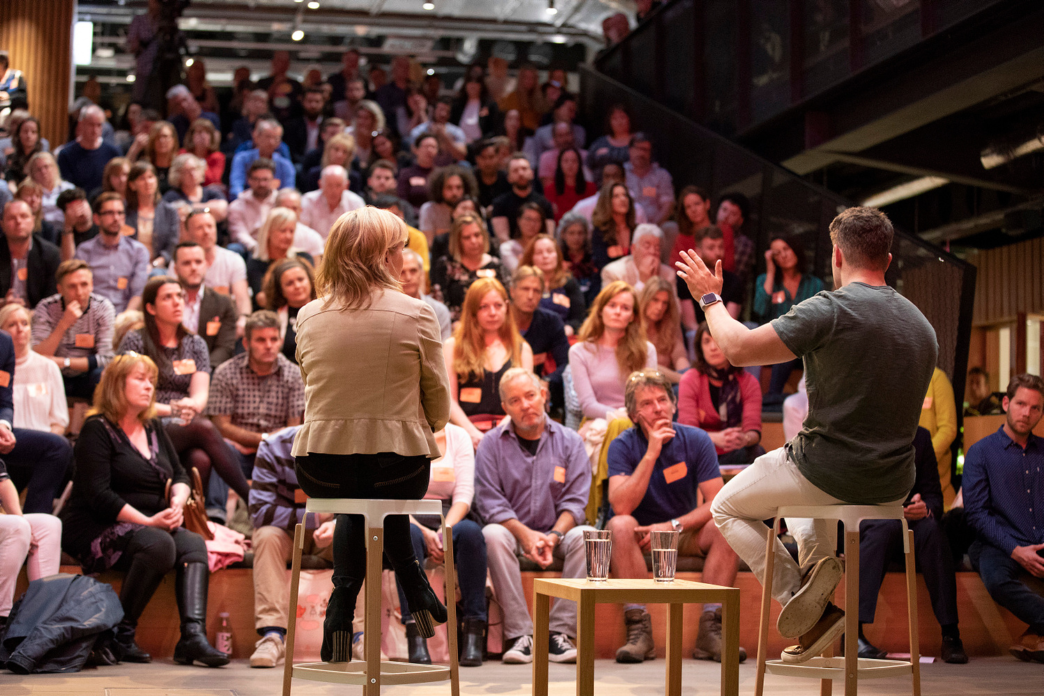 Live event with corporate speaker on stage photographed from behind addressing the audience at an Airbnb conference event photographer Dublin