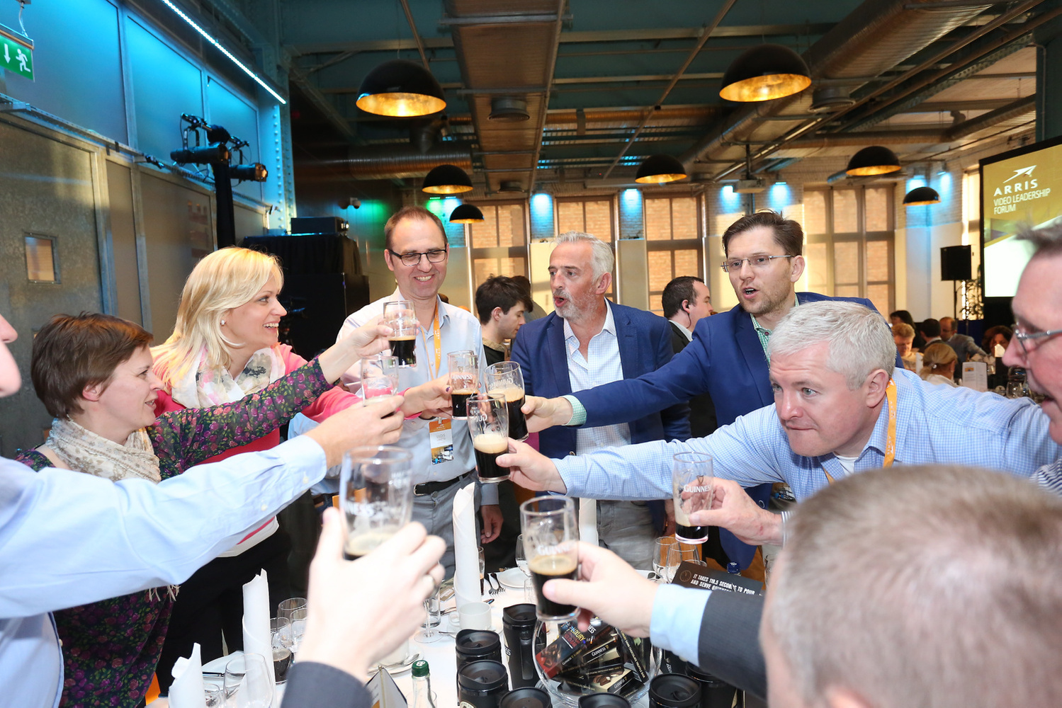 A fun photo of a group of Corporate employees attending the Arris conference and drinking pints of Guinness at the Guinness Storehouse in Dublin 