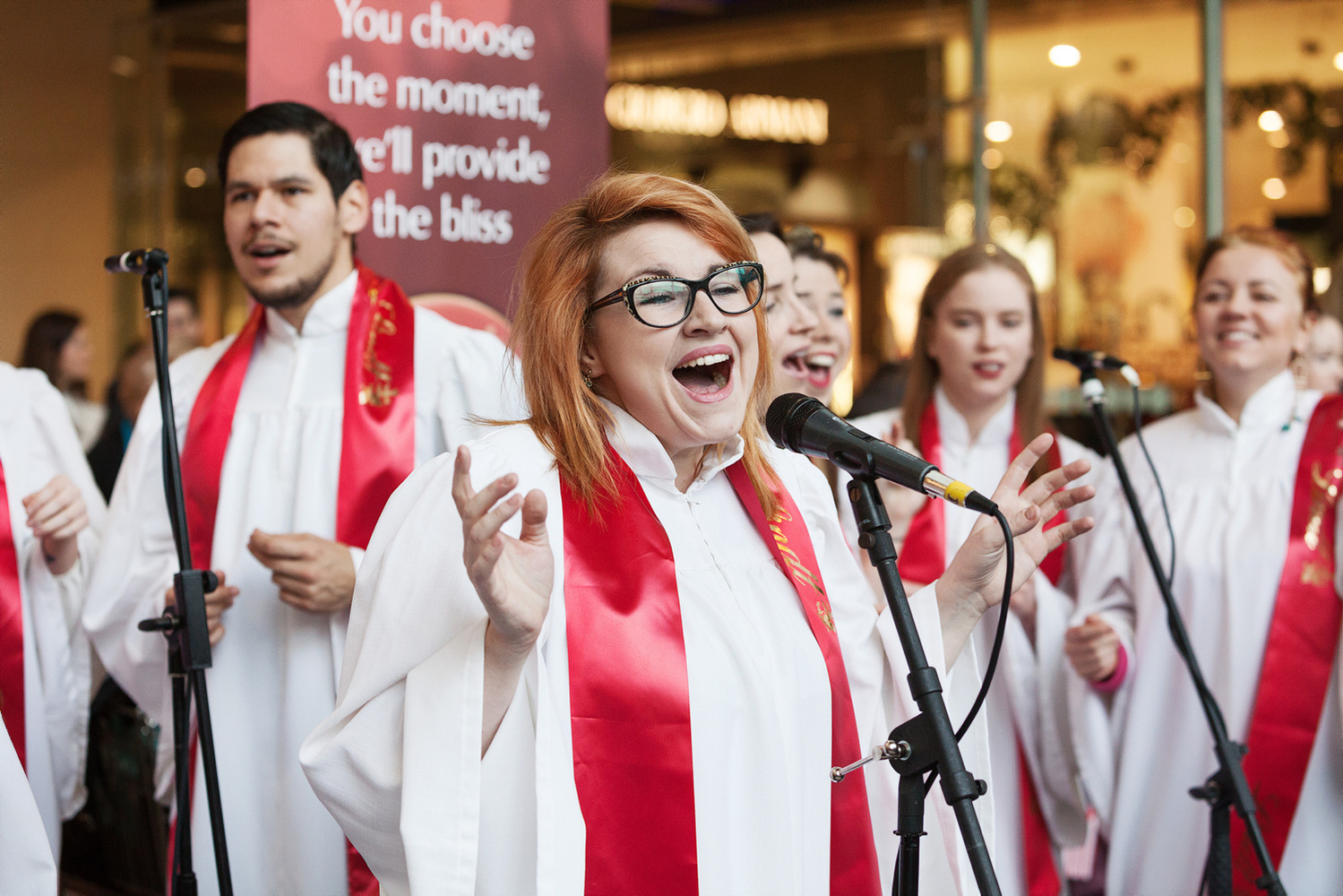 Gospel singers wearing branded red silk scarves at Lindt Chocolate Christmas seasonal promotional event in Dundrum Town Centre. PR event photographer Dublin