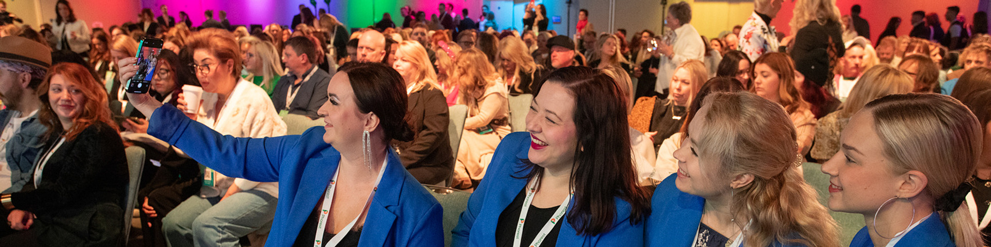 Live event photo of female delegates in the audience at a summit in Dublin taking a selfie. Taken by a professional event photographer www.eventimage.ie 
