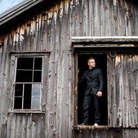 Cobblestone Wedding Barn photo - Groom standing in an opening in the barn