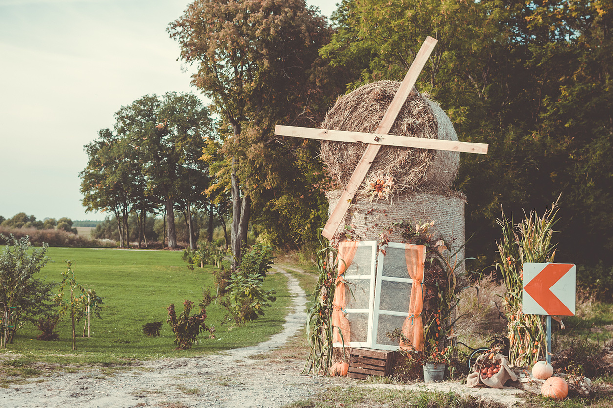 Zakręt szosy i polna droga, a na rozdrożu wrześniowa dekoracja dożynkowa w jednej z wsi Roztocza Południowego