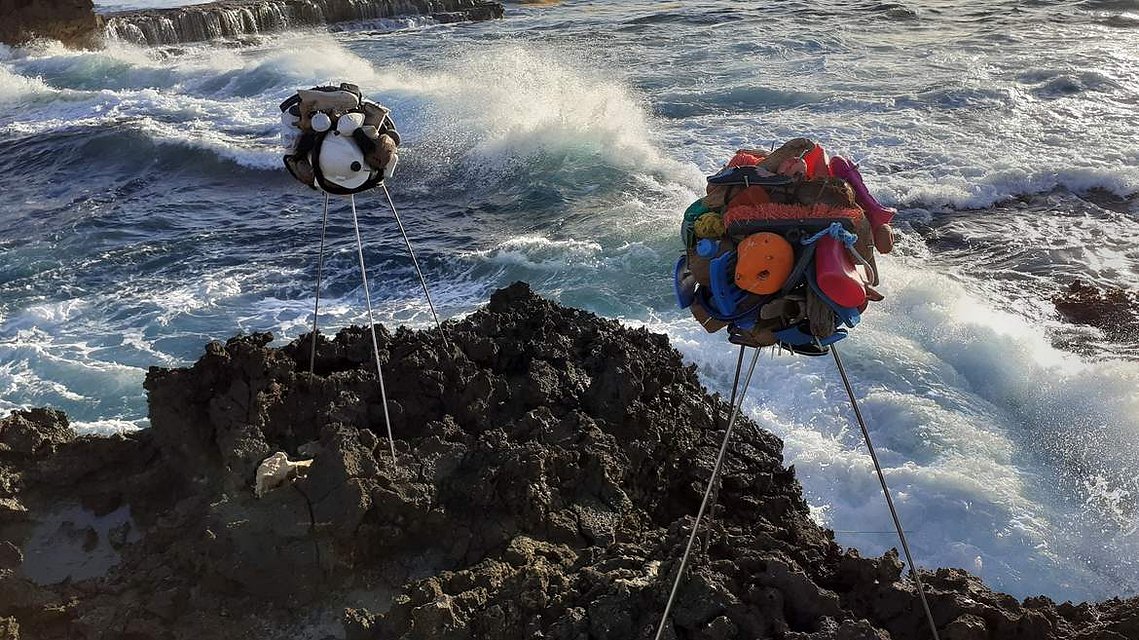 Sculptures in the landscape of the Carribean West Indies sea, on the rocks and in front of a wave