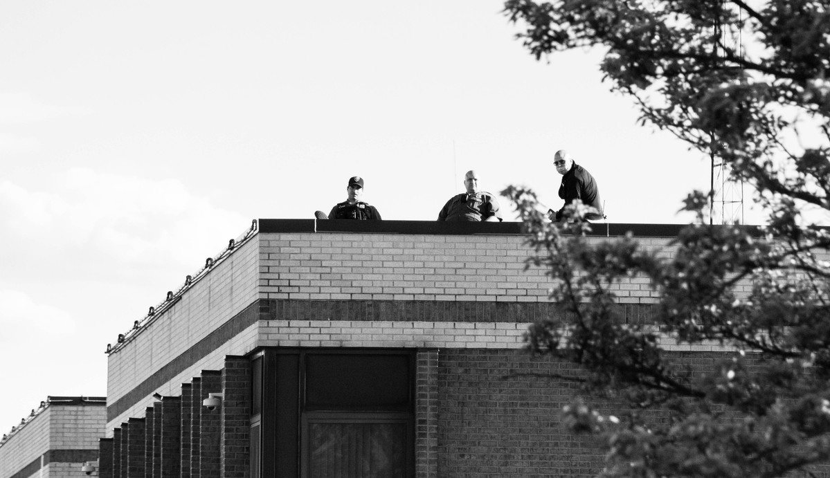Three policemen sitting on the municipal building in Asbury Park, NJ.