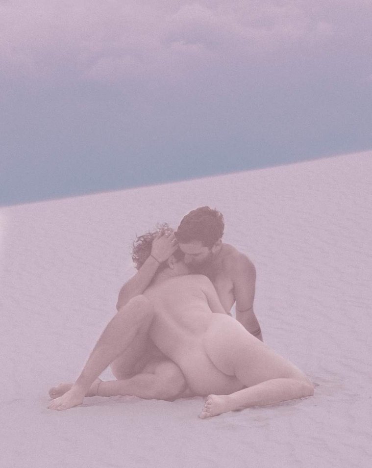 Nude couple embraces at sunset at White Sands National Monument, New Mexico