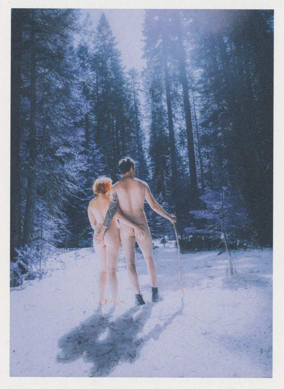 Vintage film nude photograph of couple standing in snow in winter landscape at Yosemite National Park