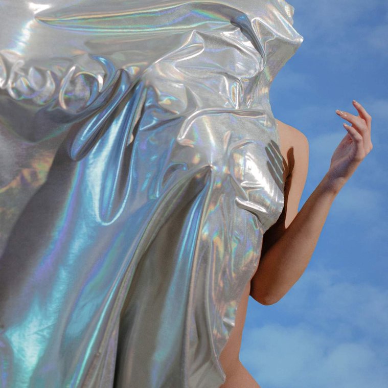 Abstract cover album art for New Zealand band Sachi, silver fabric on body against blue cloudy sky