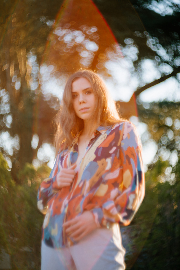 Portrait of Maren Hill, musician, with lens flare, at sunset in Los Angeles, CA