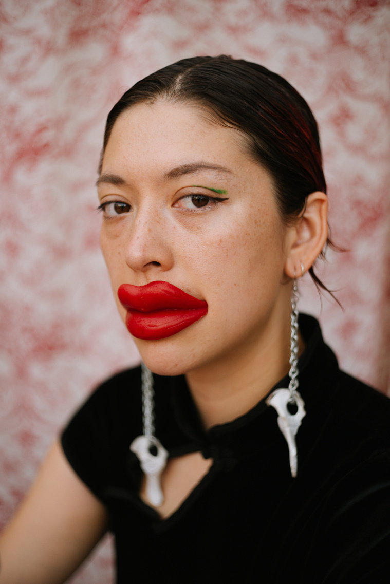 Portrait wearing wax lips against pattern backdrop