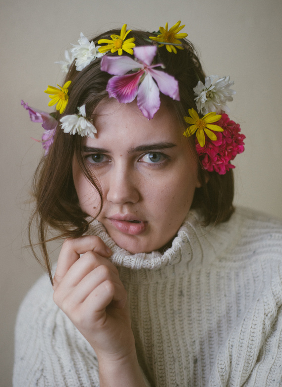 Portrait of woman wearing turtleneck and assorted flowers in her hair
