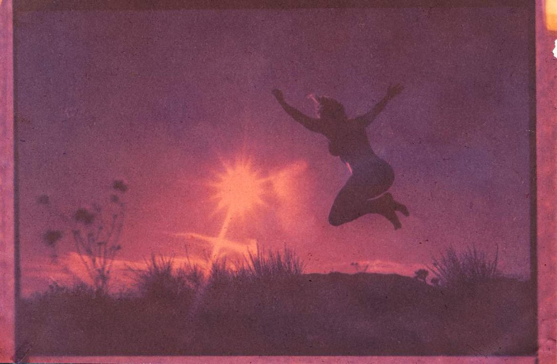 Lumen print of girl jumping against pink sunset in Joshua Tree National Park