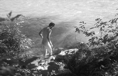 Black and white photo of nude man descending into river in Olympic National Forest, Washington