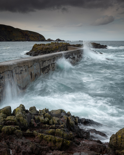 High tide waves against the harbour wall at St Abby, Scotland. A photograph by Tim Pearson