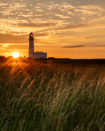 The sun sets behind Flamborough Lighthouse. A photograph by Tim Pearson.