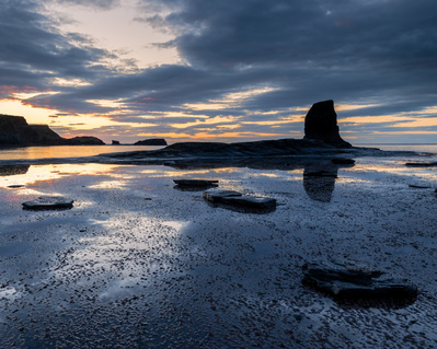 Sunset at Saltwick Bay, North Yorkshire, with Black Nab in the background. A photograph by Tim Pearson