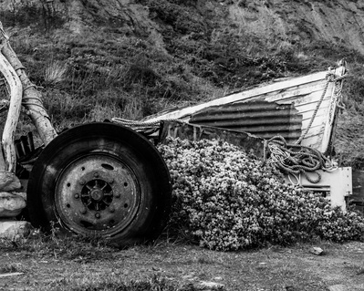 Neglected fishing boat and tractor wheel at Port Mulgrave, North Yorkshire. A photograph by Tim Pearson.