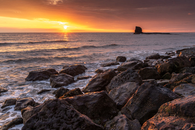 Black Nab rock, Saltwick Bay in North Yorkshire at dawn on the longest day. A photograph by Tim Pearson.