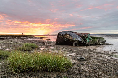A vivid sunrise lights the boat graveyard at Hoo on the Medway, Kent. A photograph by Tim Pearson.