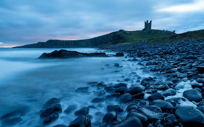 Sunrise at Dunstanburgh Castle. A photograph by Tim Pearson.