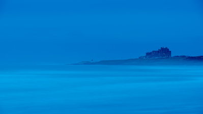 Bamburgh Castle at dawn, viewed from Ross Sands. A photograph by Tim Pearson.