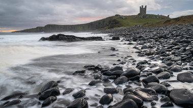 Sunrise behind Dunstanburgh Castle, Northumbria, on New Year's Day. A photograph by Tim Pearson.