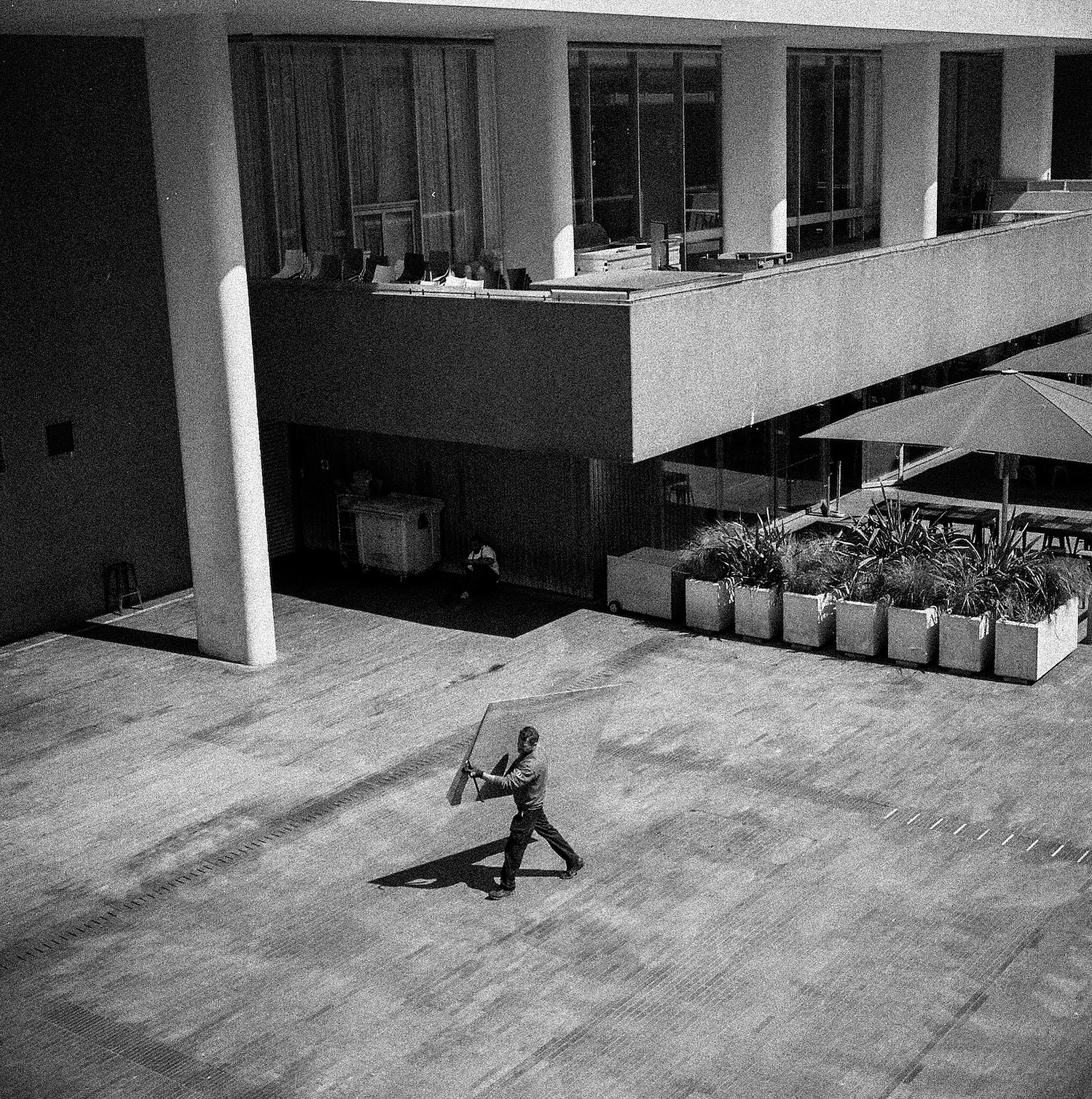 A man carries an object seen from above