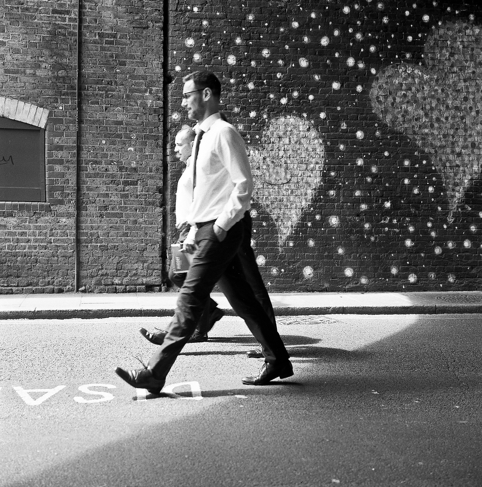 Men walk past heart shaped graffiti