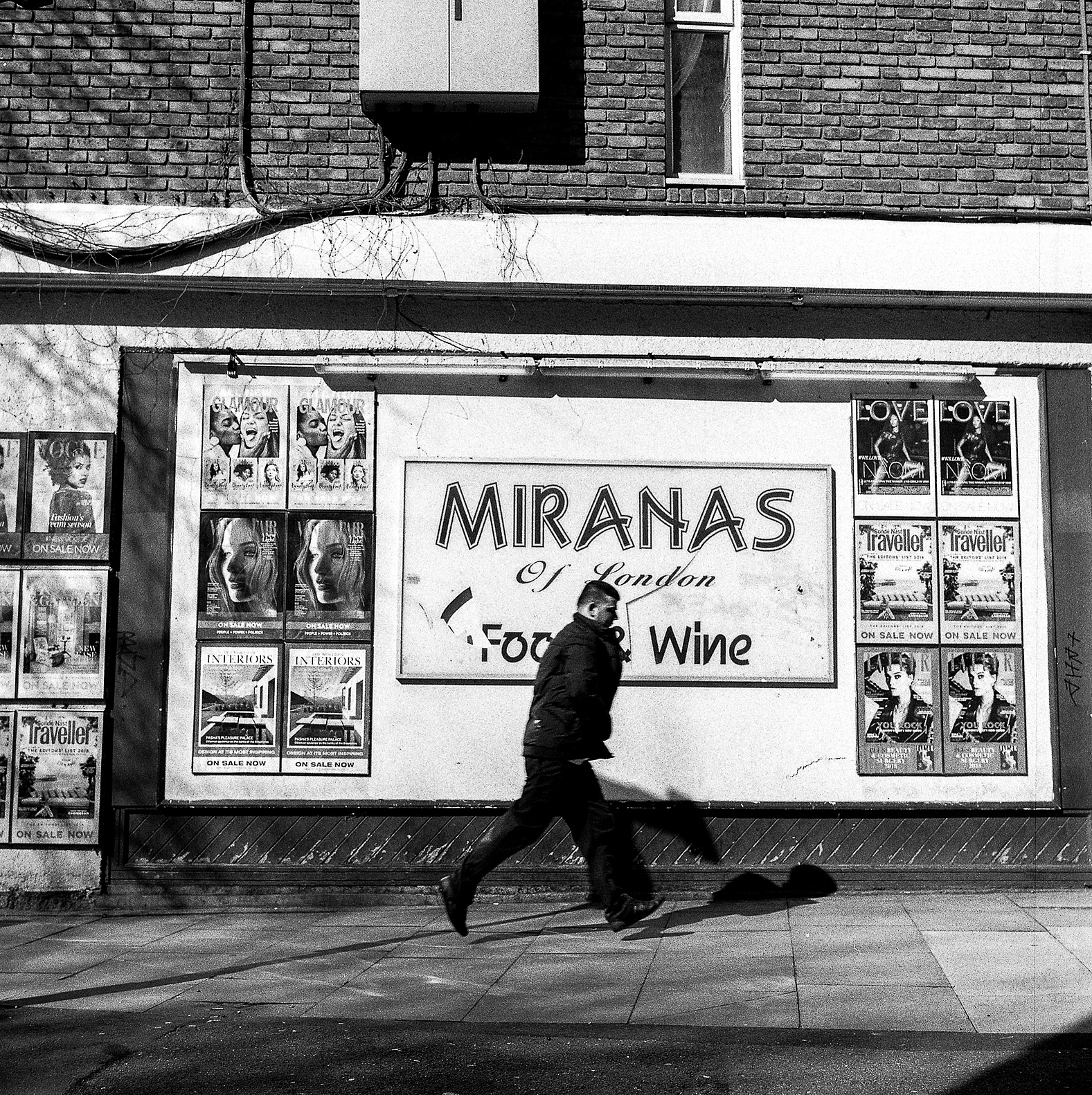 A man in a hurry passes a billboard.