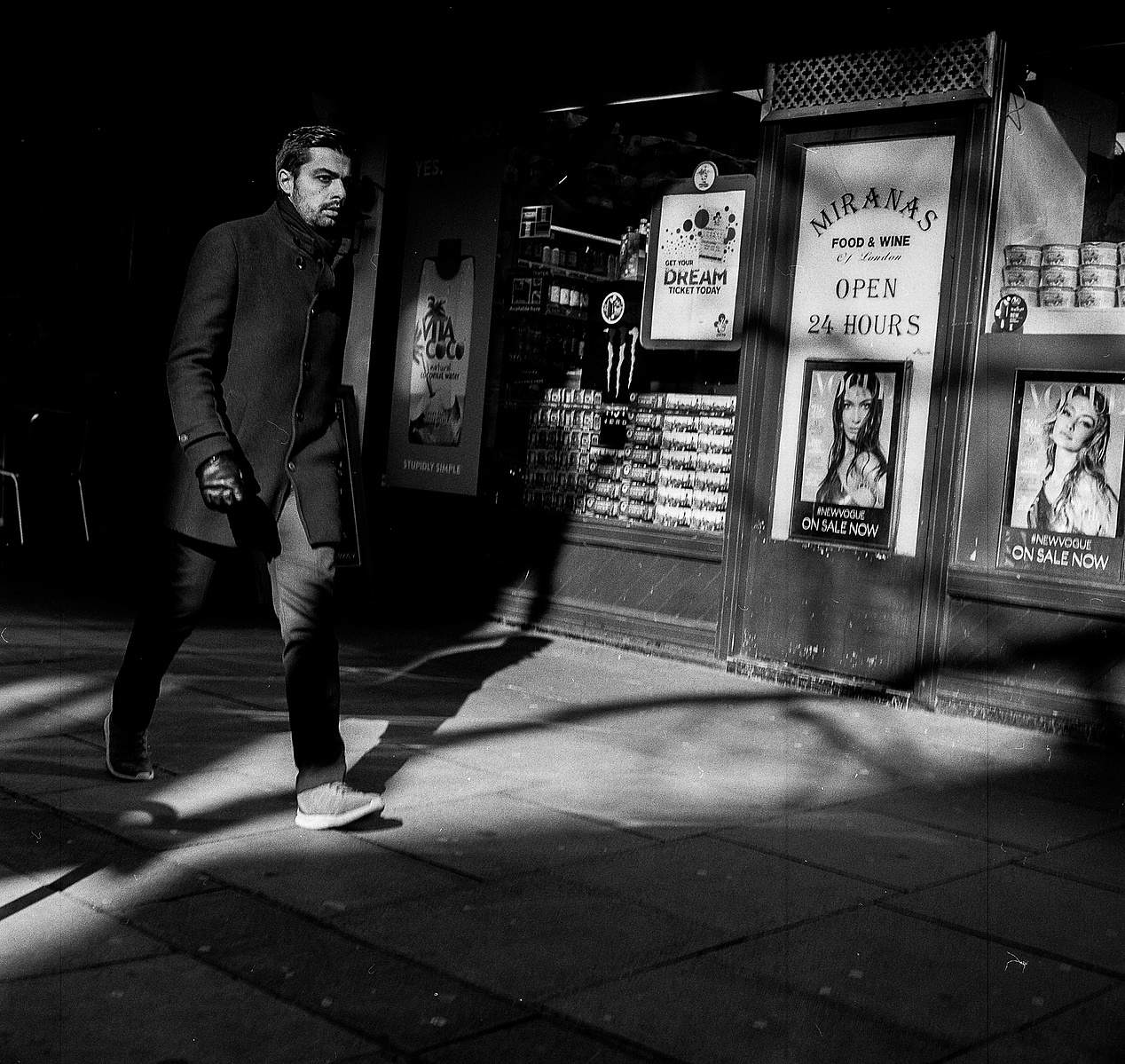A man walks past a convenience store.