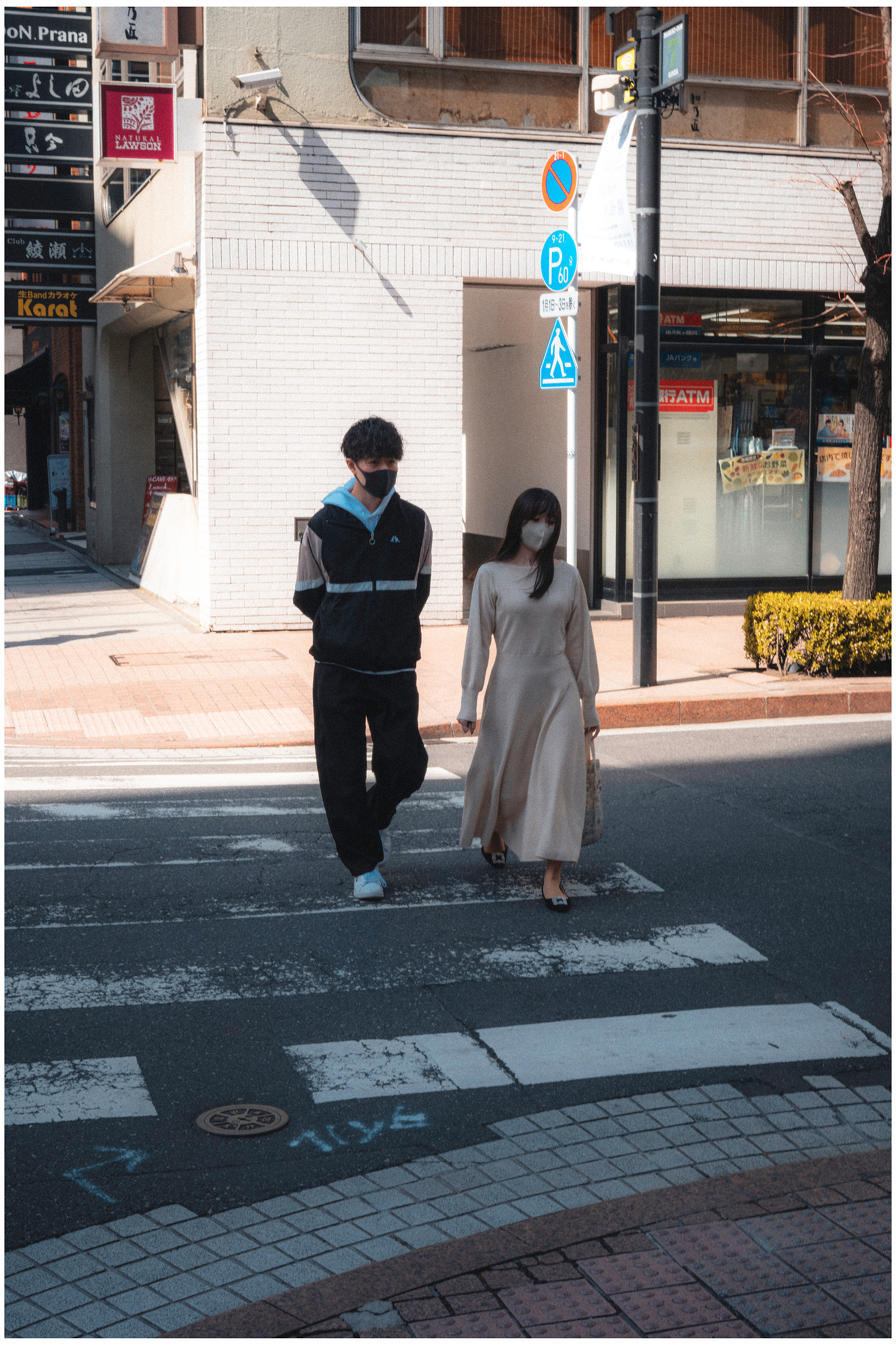A couple walk across the road