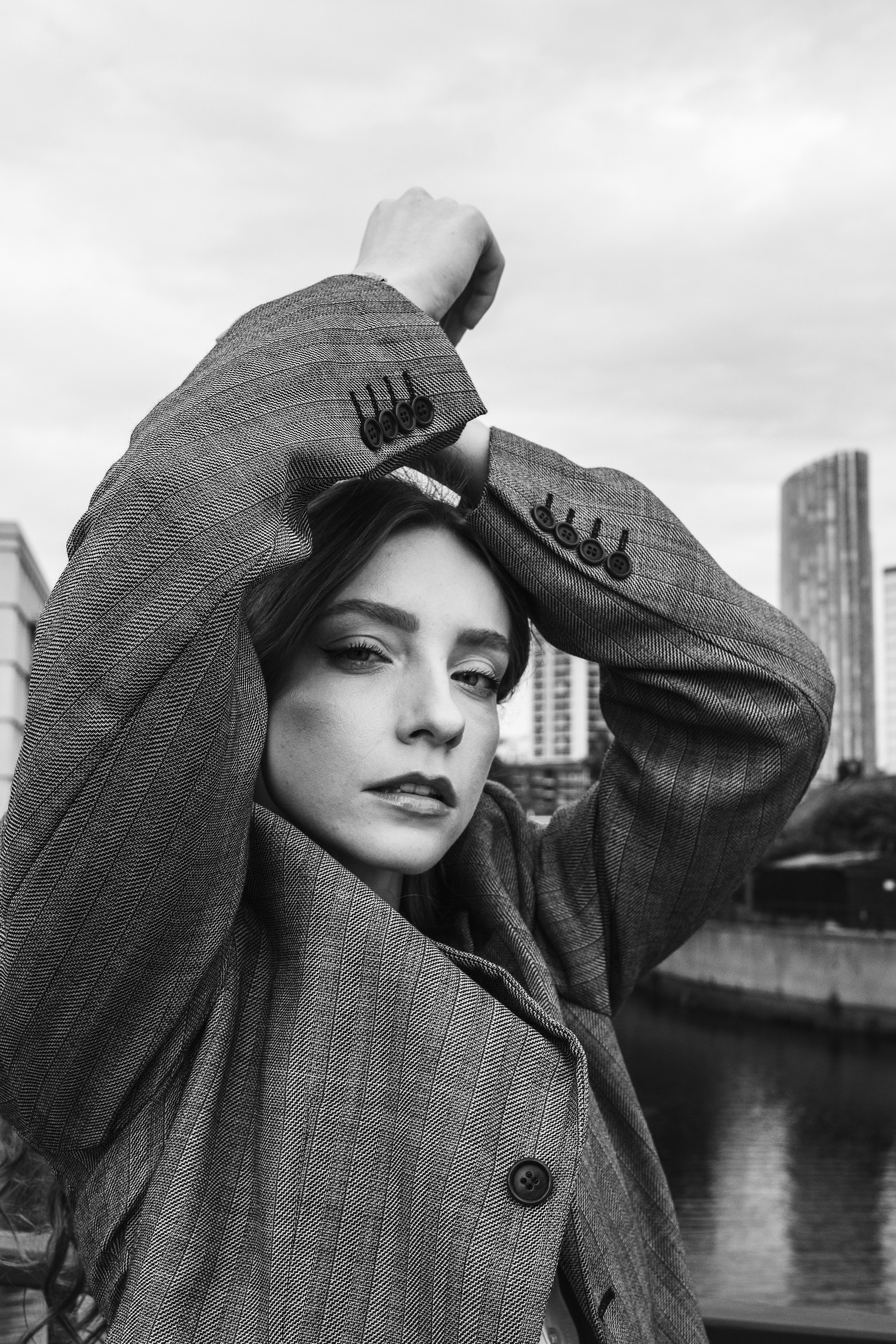 woman in a jacket arms over hear head