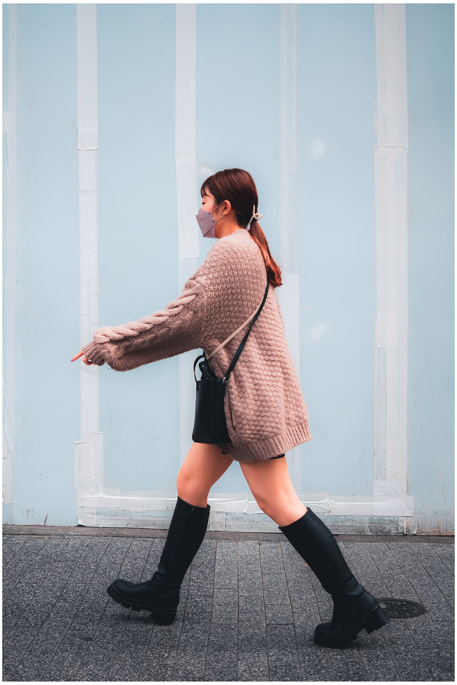 Well dressed woman in boots passes the camera