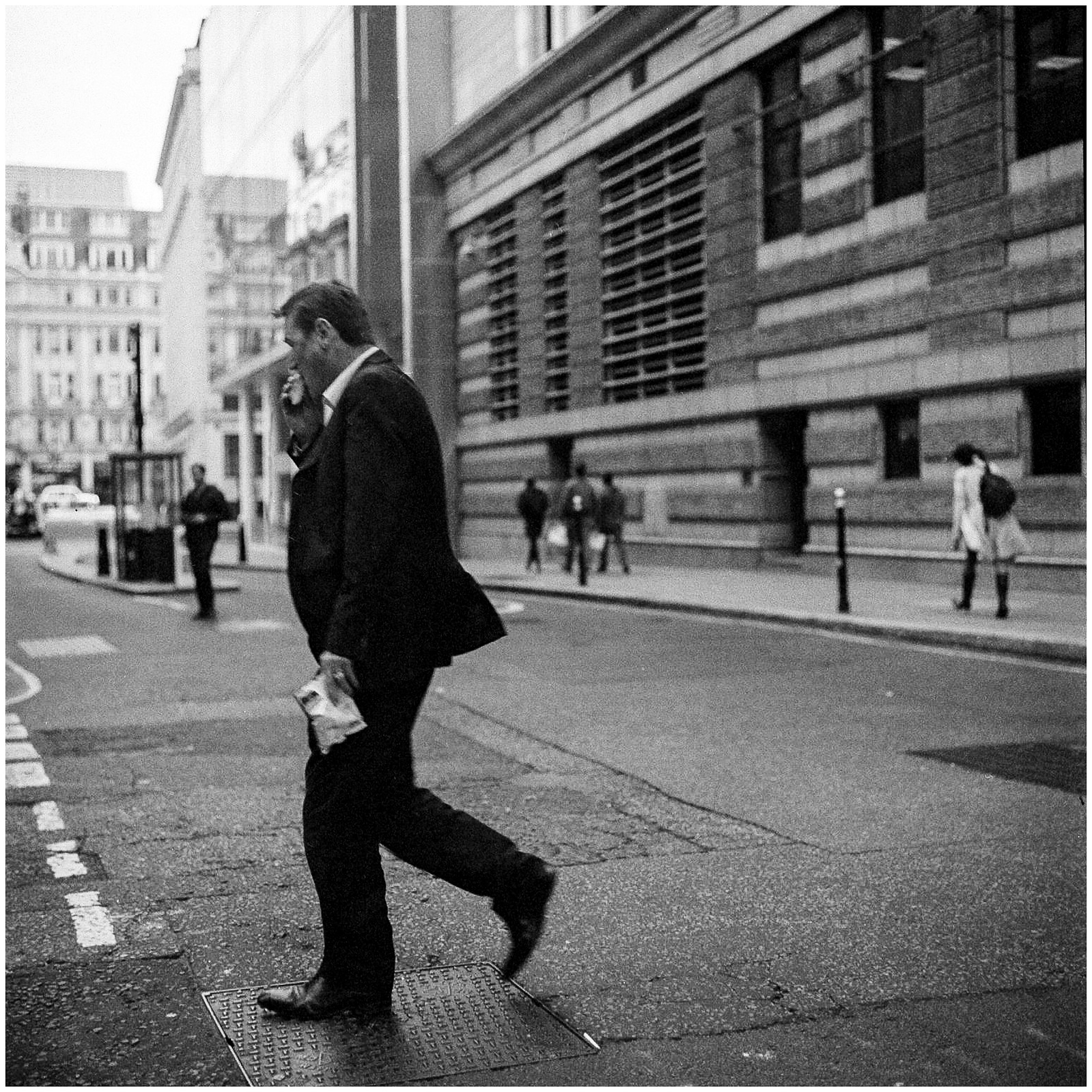 A man eating a sandwich while walking.