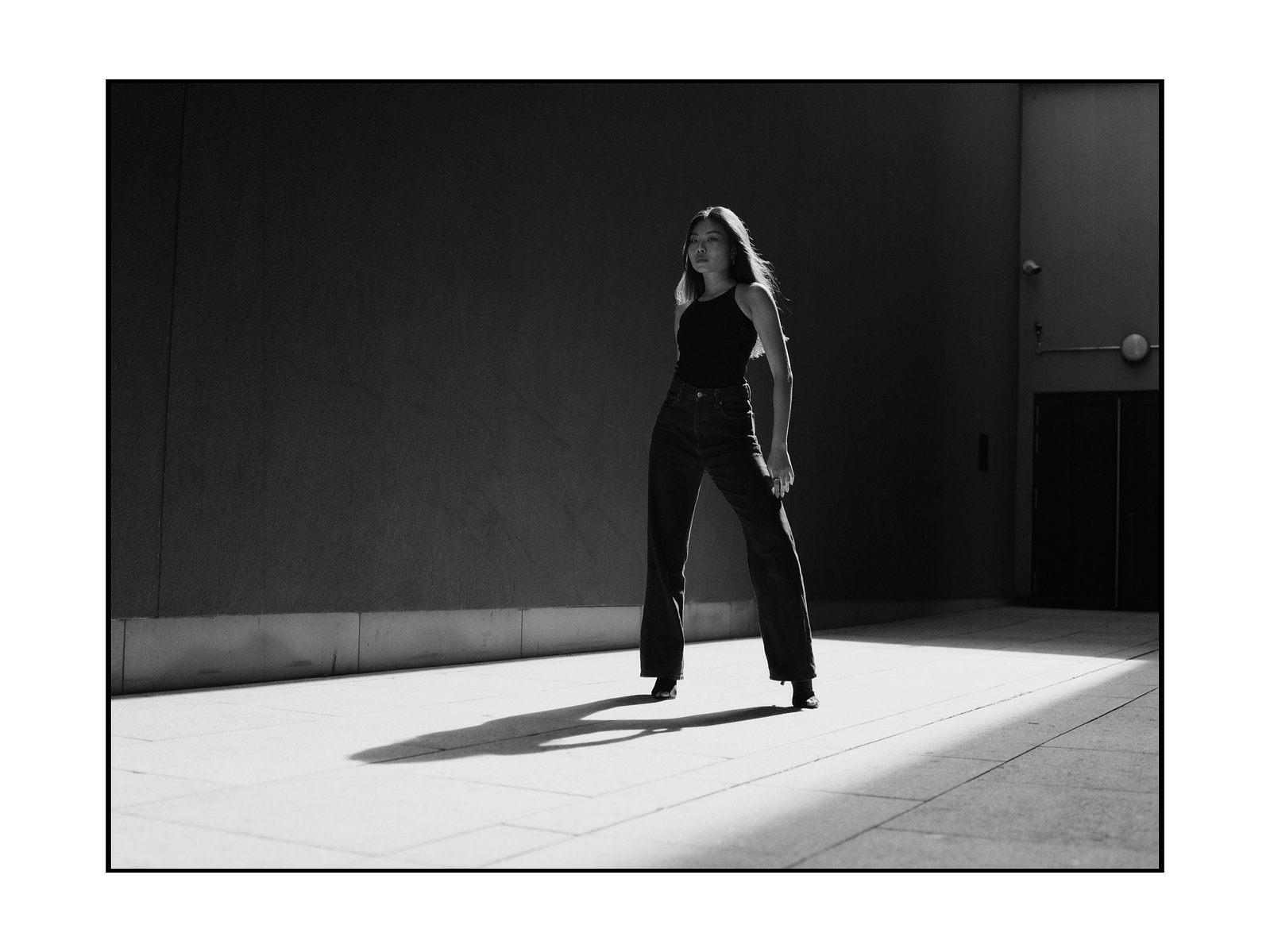 woman standing in light posing.
