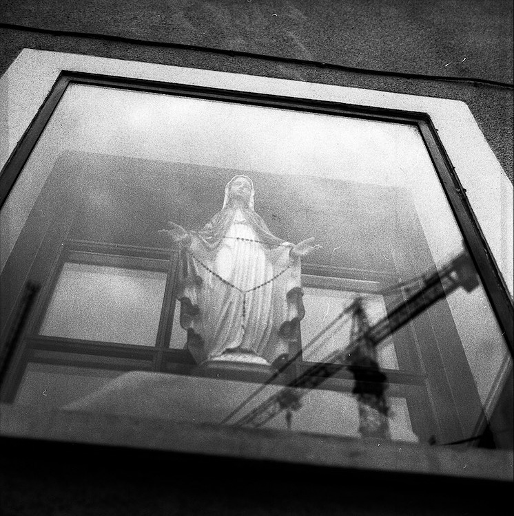 Virgin Mary statue through a window.