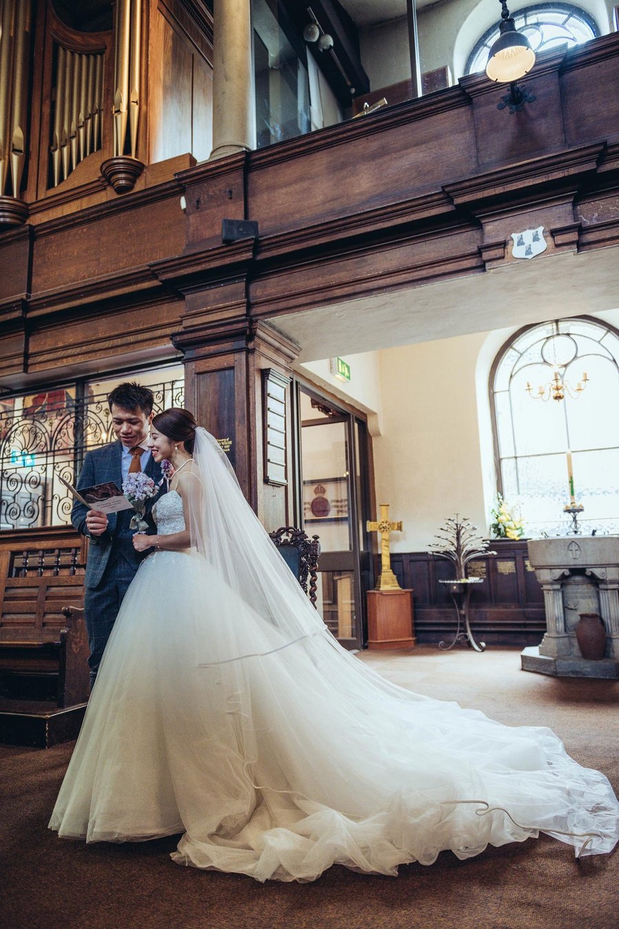 candid and natural wedding photography, city centre urban wedding, couple in church singing from hymn sheet