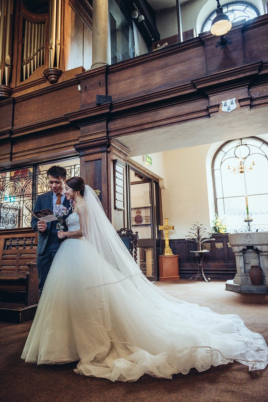 candid and natural wedding photography, city centre urban wedding, couple in church singing from hymn sheet