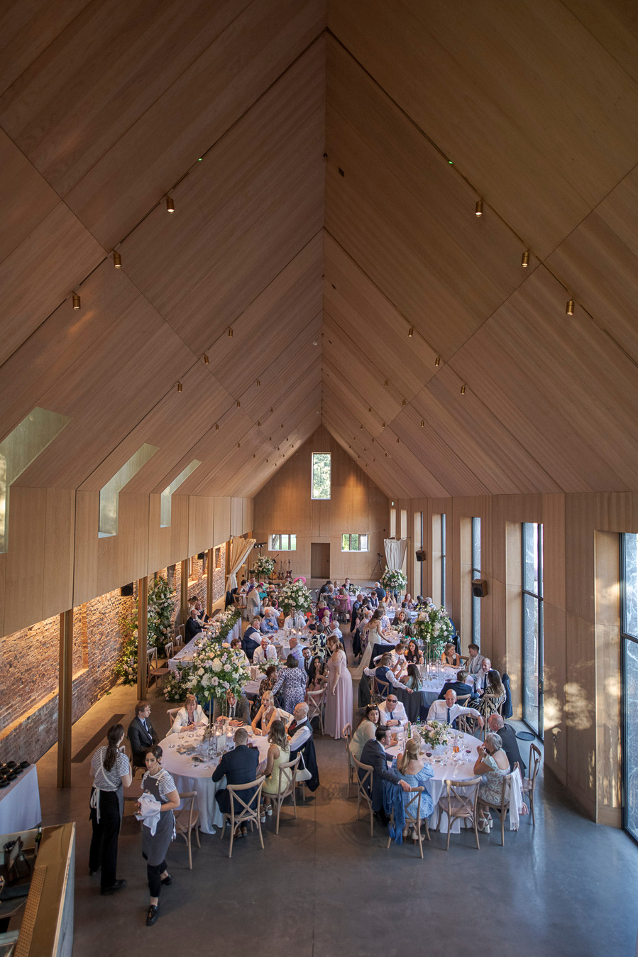 natural and authentic wedding photography, wide shot of dining reception at wedding with modern interior