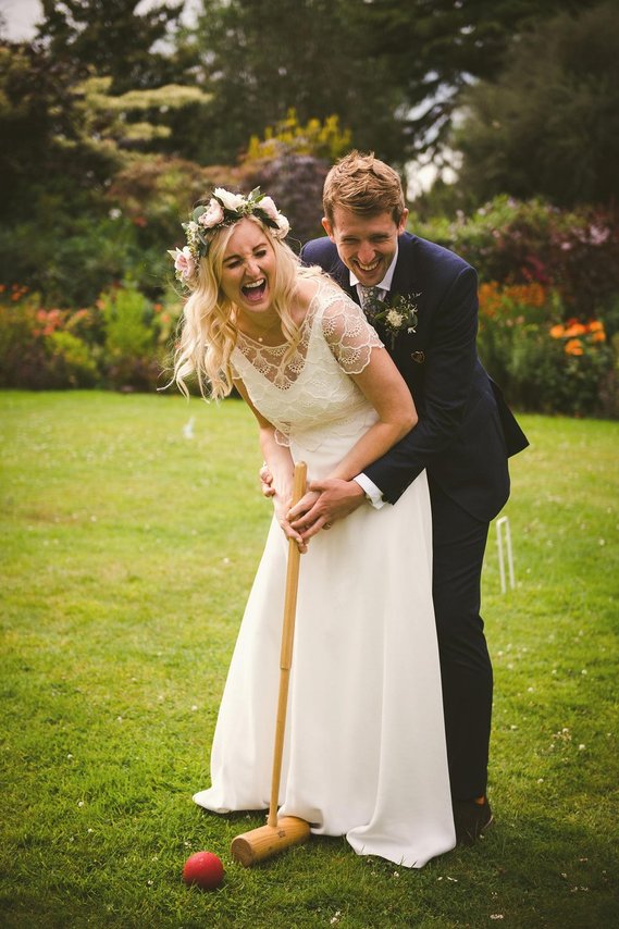 wedding photography, bride and groom laughing while playing croquet