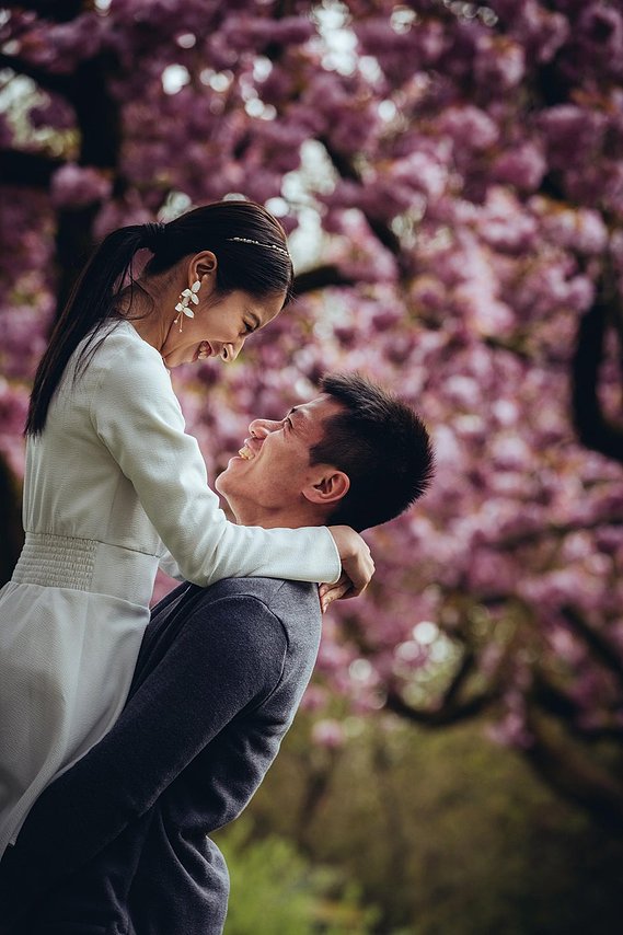 candid and natural wedding photography, city centre urban wedding, wedding couple, engagement shoot, couple hugging and laughing under blossom trees