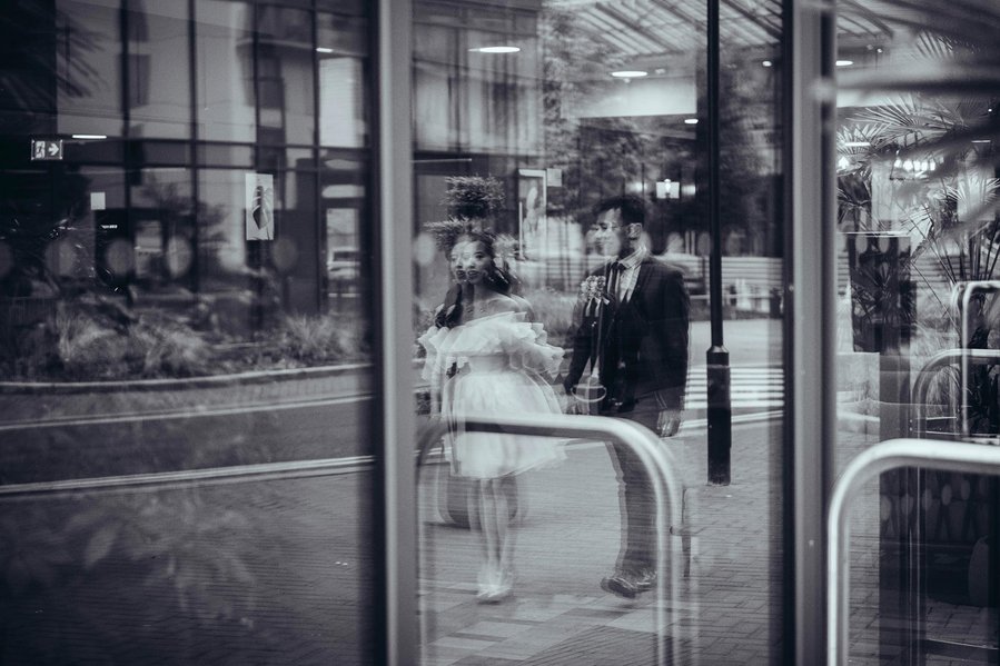candid and natural wedding photography, city centre urban wedding, wedding couple seen in reflection in window