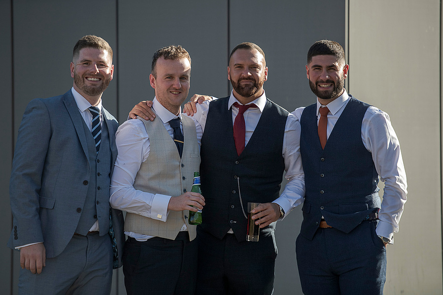 natural and authentic wedding photography, groom and friends pose for photo