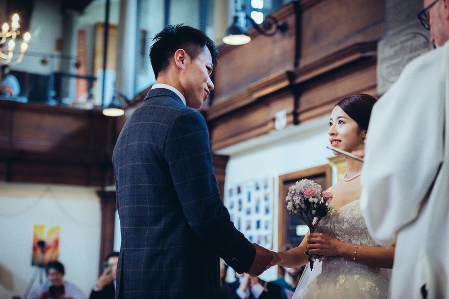 candid and natural wedding photography, city centre urban wedding, wedding couple facing each other as they get married in church