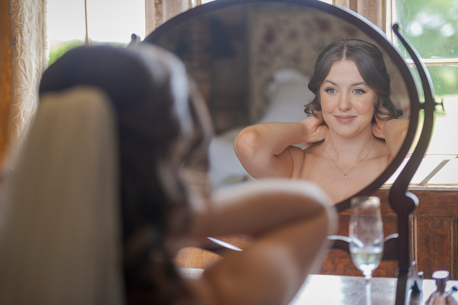 natural and authentic wedding photography, bride getting ready sitting in front of mirror
