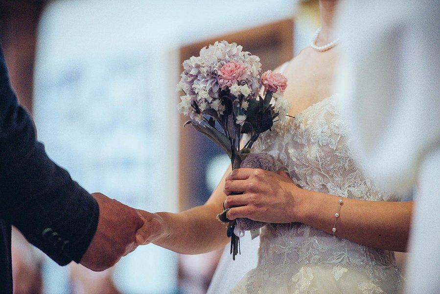 candid and natural wedding photography, city centre urban wedding, cropped shot of bride's flowers in church