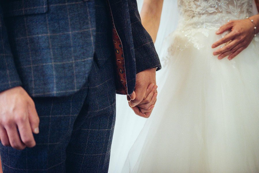 candid and natural wedding photography, city centre urban wedding, cropped shot of bride and groom holding hands