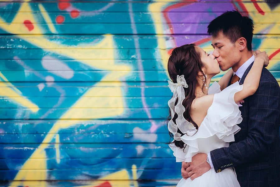 candid and natural wedding photography, city centre urban wedding, wedding couple portrait, couple kiss in front of graffiti
