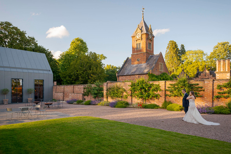 natural and authentic wedding photography, bride and groom walking through grounds of period wedding venue 