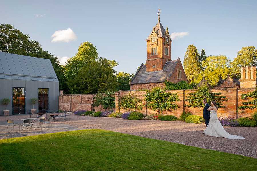 natural and authentic wedding photography, bride and groom walking through grounds of period wedding venue 